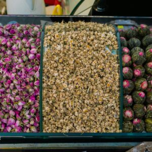Top view of assorted dried flowers including rosebuds, chamomile, and blooming teas for herbal blends.