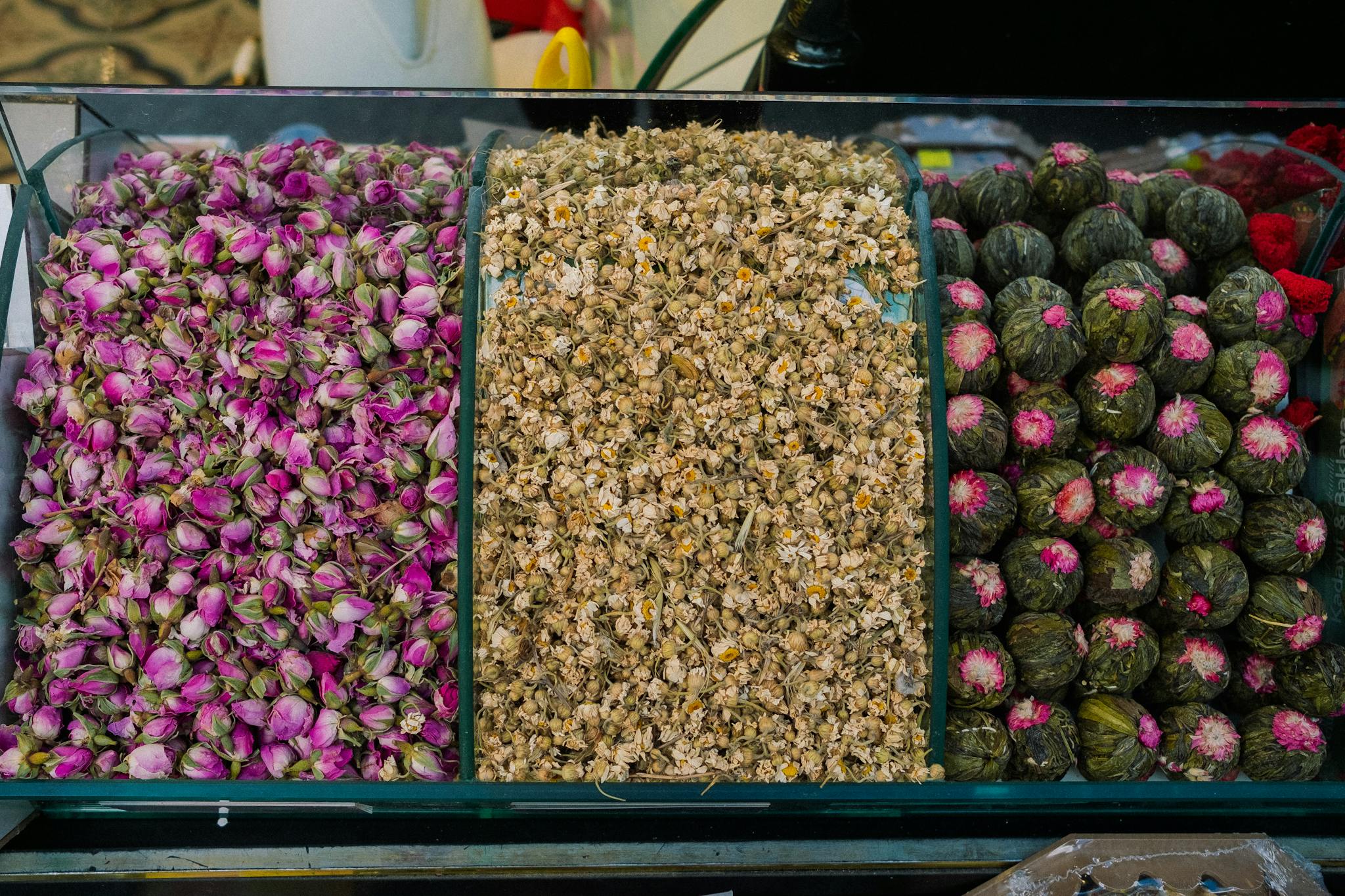 Top view of assorted dried flowers including rosebuds, chamomile, and blooming teas for herbal blends.